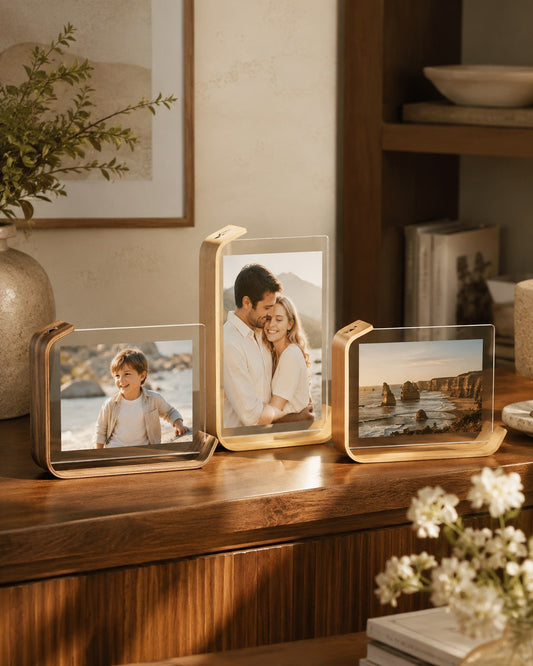 Curved clear tabletop photo frames styled on a warm wood console